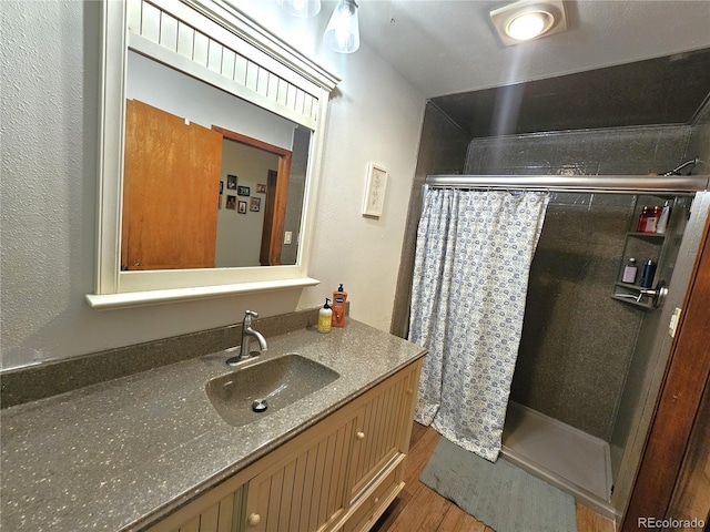 bathroom featuring vanity, a shower with shower curtain, and wood finished floors