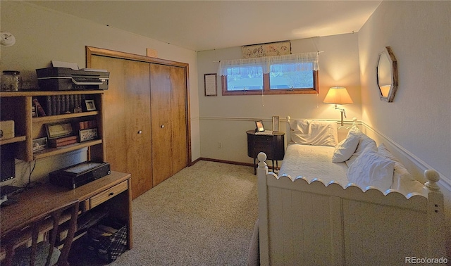 carpeted bedroom featuring a closet and baseboards