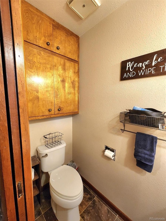 bathroom featuring toilet, baseboards, and tile patterned floors