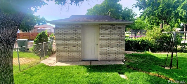view of shed with fence and a trampoline