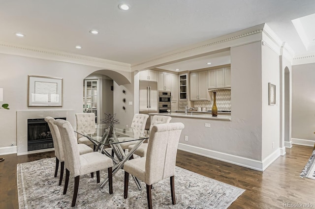 490 Columbine St Unit 5, Denver, CO 80206 - dining room featuring arched walkways, dark wood finished floors, recessed lighting, a fireplace, and ornamental molding