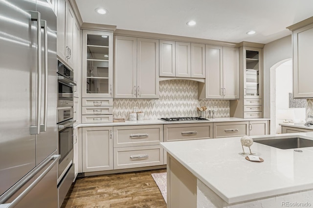 490 Columbine St Unit 5, Denver, CO 80206 - kitchen with stainless steel appliances, wood finished floors, tasteful backsplash, light countertops, and recessed lighting