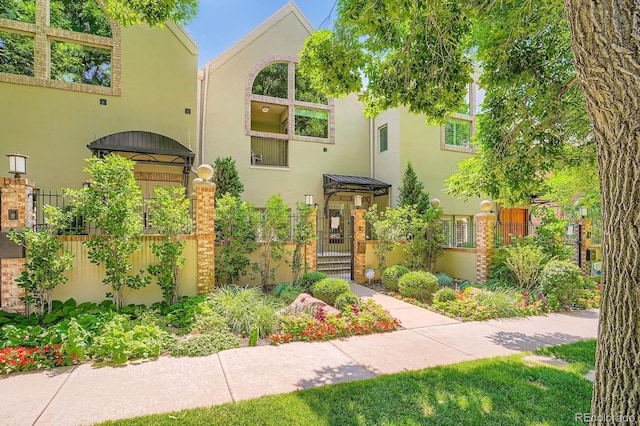 490 Columbine St Unit 5, Denver, CO 80206 - mediterranean / spanish home featuring stucco siding, a gate, and a fenced front yard