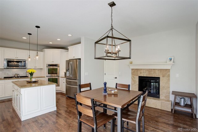 4542 Valleybrook Dr, Highlands Ranch, CO 80130 - dining room with dark wood-type flooring, recessed lighting, a high end fireplace, and a chandelier