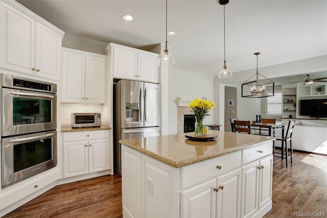 4542 Valleybrook Dr, Highlands Ranch, CO 80130 - kitchen featuring stainless steel appliances, dark wood finished floors, a kitchen island, pendant lighting, and recessed lighting