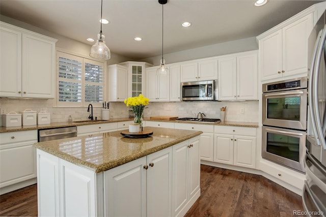 4542 Valleybrook Dr, Highlands Ranch, CO 80130 - kitchen with appliances with stainless steel finishes, a sink, white cabinetry, a center island, and recessed lighting