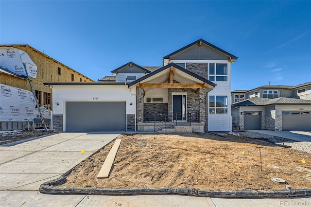 view of front of property with an attached garage, stone siding, and concrete driveway