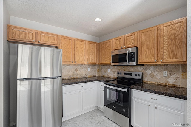 18954 E 57th Pl Unit D, Denver, CO 80249 - kitchen featuring stainless steel appliances, decorative backsplash, recessed lighting, a textured ceiling, and white cabinetry