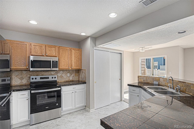 18954 E 57th Pl Unit D, Denver, CO 80249 - kitchen featuring stainless steel appliances, tasteful backsplash, a textured ceiling, recessed lighting, and tile counters