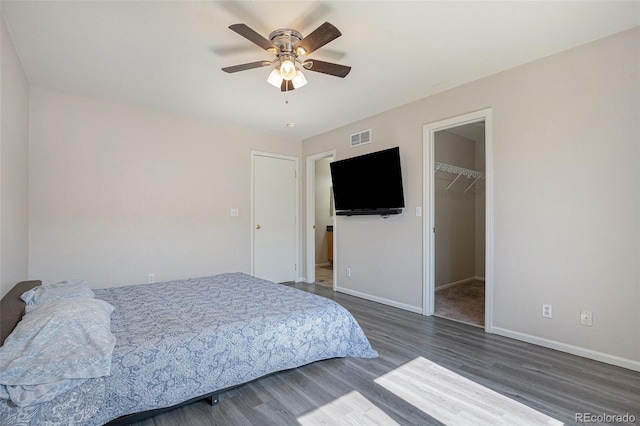 18954 E 57th Pl Unit D, Denver, CO 80249 - bedroom with wood finished floors, a spacious closet, a ceiling fan, and a closet