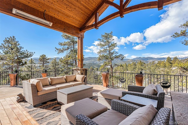 wooden deck with a mountain view and an outdoor living space