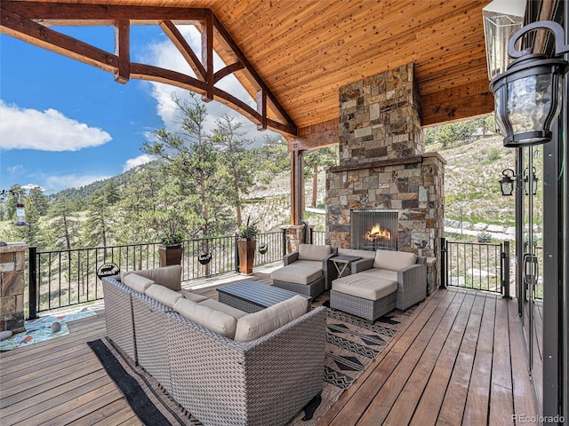 wooden deck with an outdoor living space with a fireplace