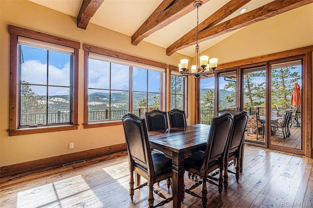 dining room featuring vaulted ceiling with beams, a mountain view, wood-type flooring, and a chandelier