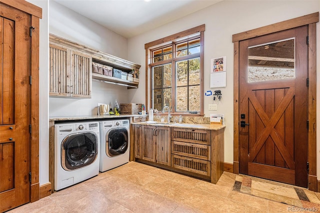 laundry room with washer and dryer, cabinets, and sink