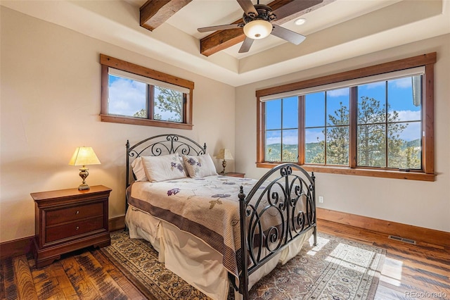 bedroom with beam ceiling, ceiling fan, and dark wood-type flooring