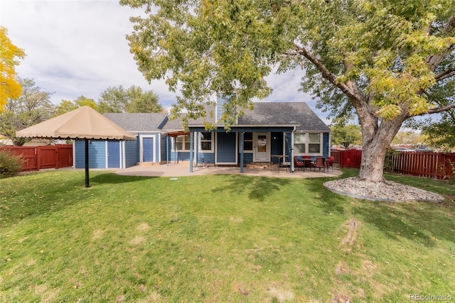 back of house with a patio area and a yard