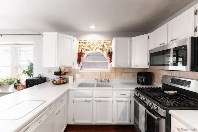 kitchen featuring white cabinets, stainless steel appliances, sink, and backsplash