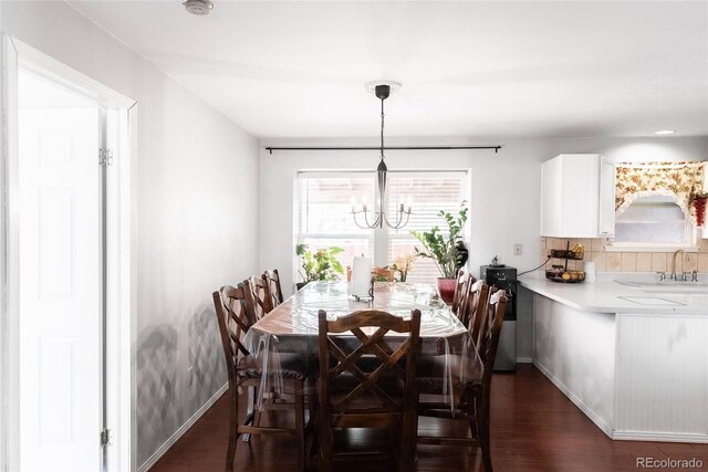 dining room with dark hardwood / wood-style floors, sink, and an inviting chandelier