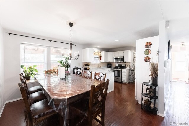 dining room with sink, dark hardwood / wood-style flooring, and a notable chandelier