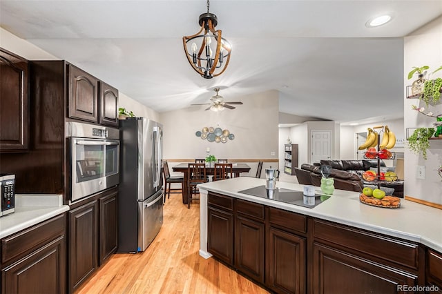 kitchen featuring dark brown cabinetry, decorative light fixtures, light wood-type flooring, appliances with stainless steel finishes, and ceiling fan with notable chandelier