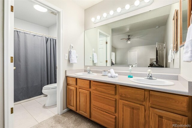 bathroom with tile patterned flooring, vanity, ceiling fan, and toilet