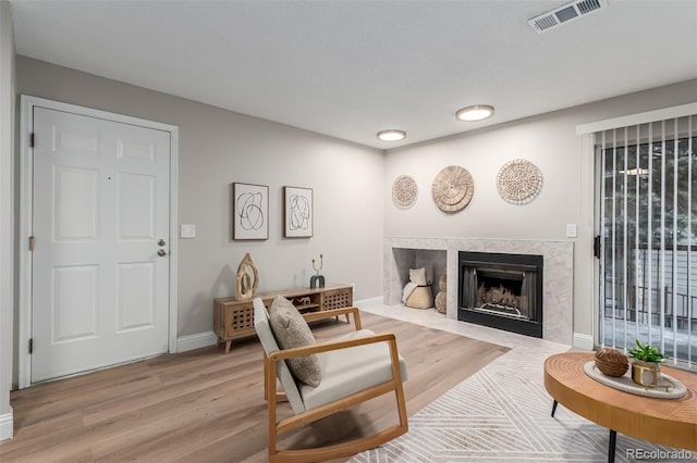 living area with a fireplace, wood finished floors, and baseboards