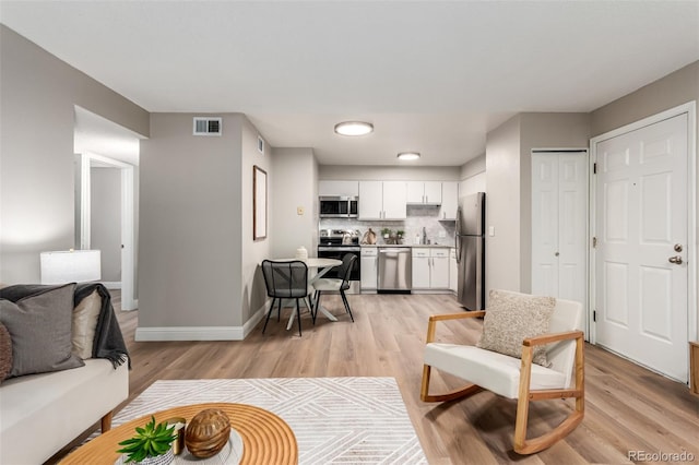 living room featuring light wood-type flooring and baseboards
