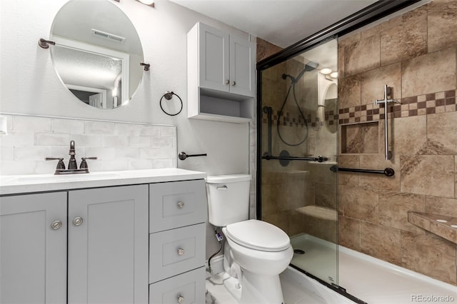 full bath with a shower stall, tasteful backsplash, vanity, and toilet
