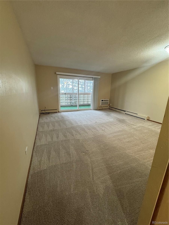 carpeted empty room with baseboards, a textured ceiling, a wall mounted air conditioner, and a baseboard radiator