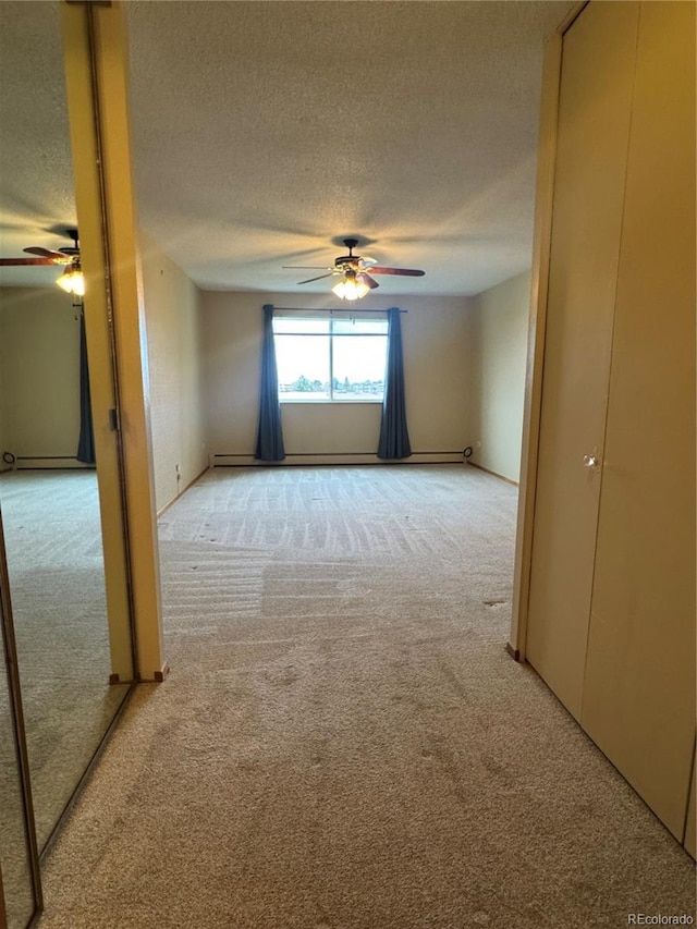 empty room with carpet floors, a ceiling fan, and a textured ceiling