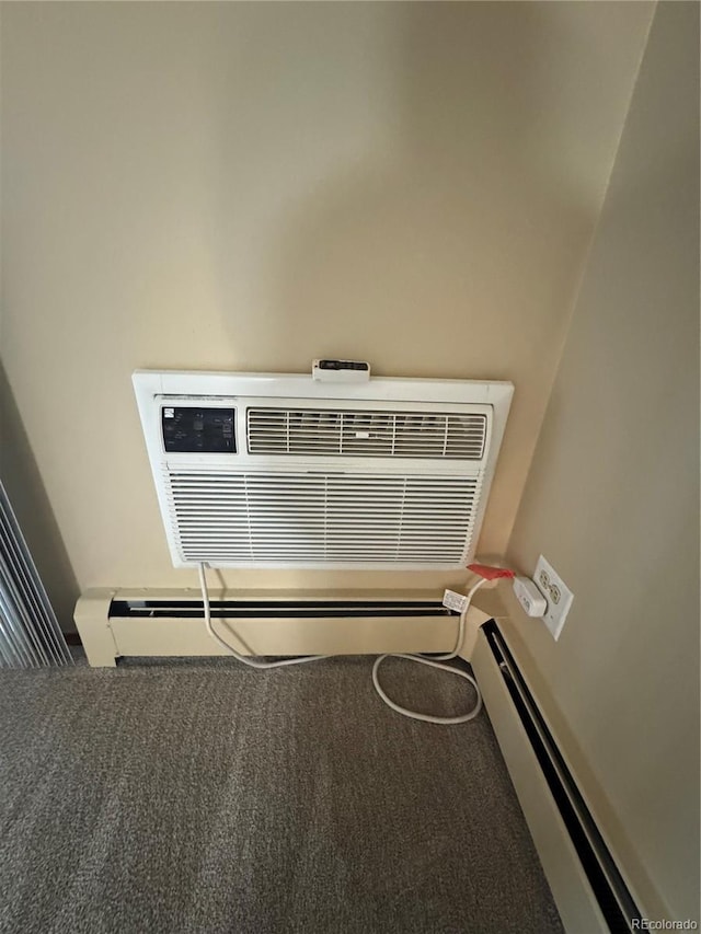 details featuring carpet floors, a baseboard heating unit, and a wall mounted air conditioner