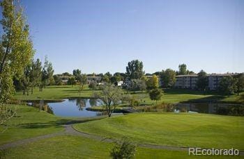 view of community with a lawn, a water view, and golf course view