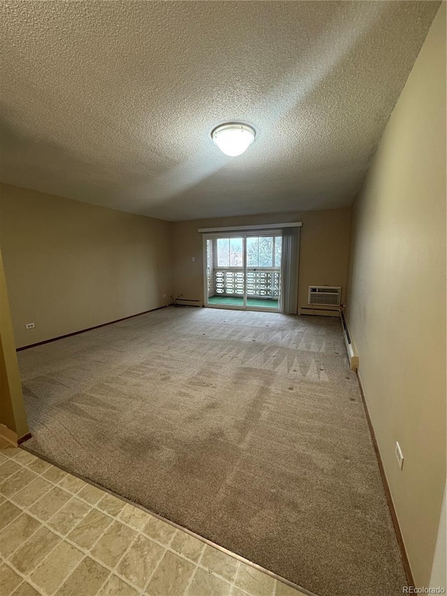unfurnished room with carpet flooring, a textured ceiling, baseboards, a wall unit AC, and a baseboard radiator