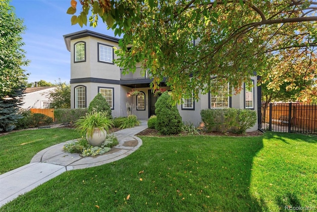 view of front of property featuring a balcony and a front lawn