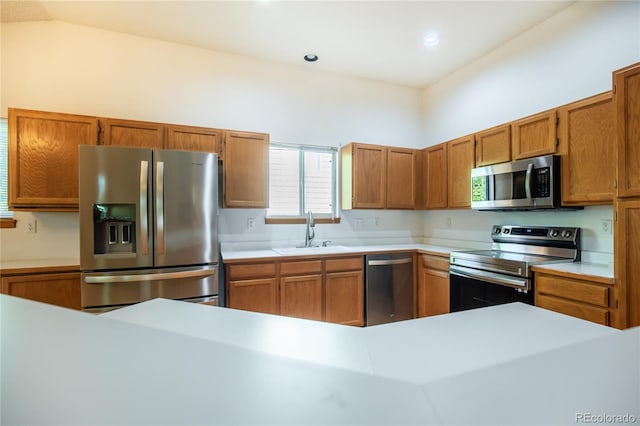 kitchen with lofted ceiling, appliances with stainless steel finishes, and sink