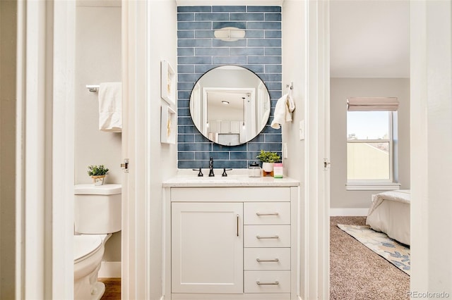 bathroom featuring toilet, backsplash, and vanity