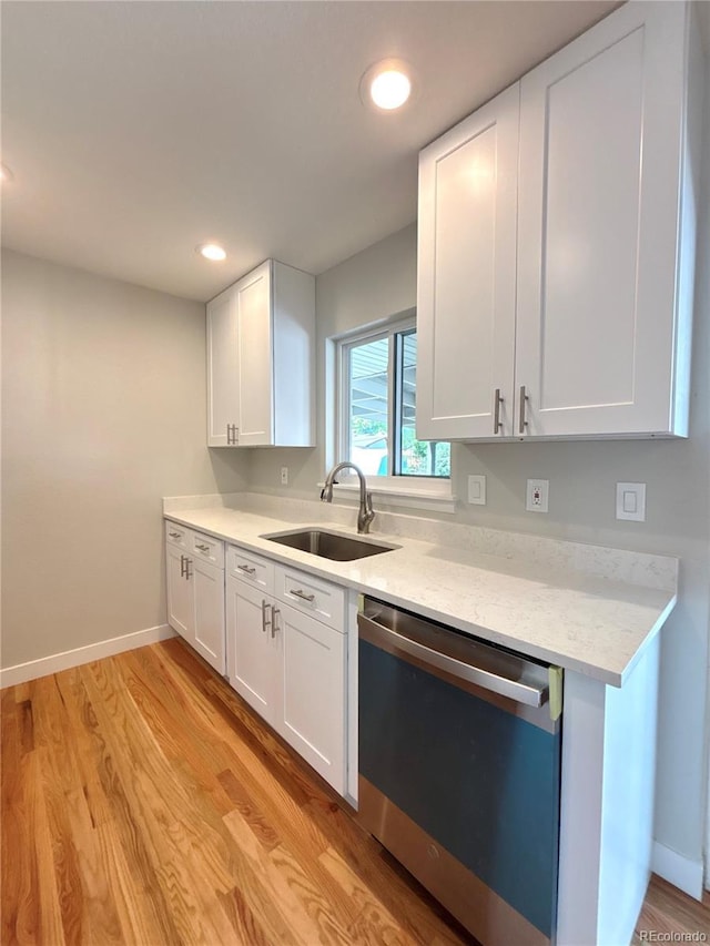 8239 Nola Dr, Denver, CO 80221 - kitchen featuring stainless steel dishwasher, white cabinetry, light wood-type flooring, and recessed lighting