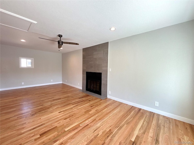 8239 Nola Dr, Denver, CO 80221 - unfurnished living room with light wood-style floors, a ceiling fan, recessed lighting, and a large fireplace