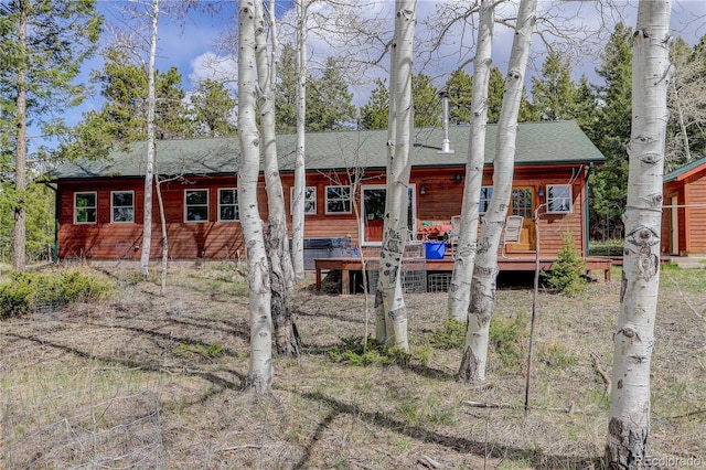 exterior space with roof with shingles and a deck
