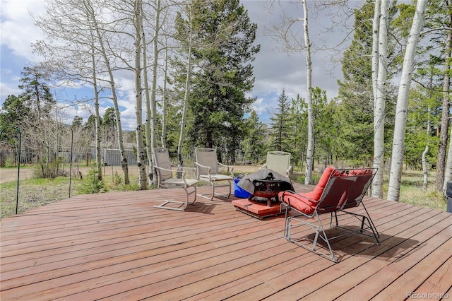 wooden terrace featuring a fire pit and fence
