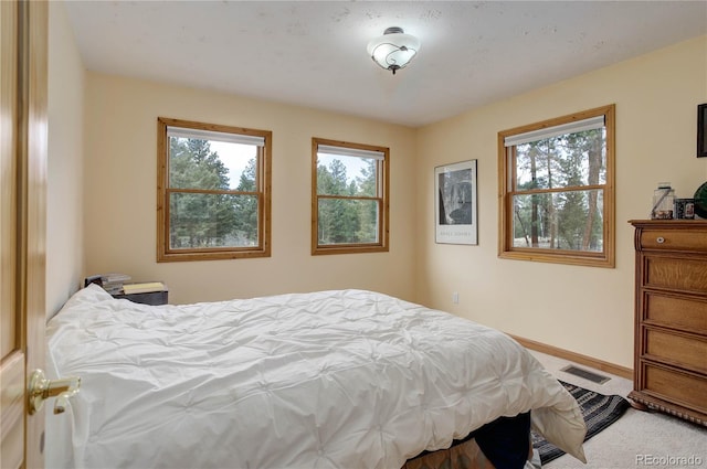 carpeted bedroom with baseboards and visible vents