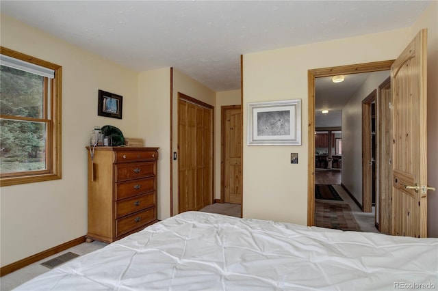 bedroom with baseboards, carpet, a closet, and visible vents