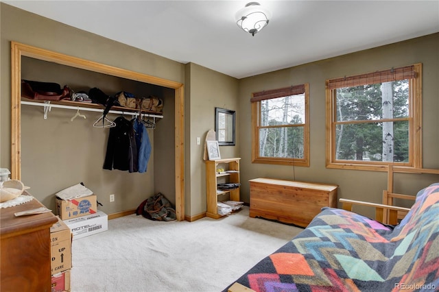carpeted bedroom featuring a closet and baseboards