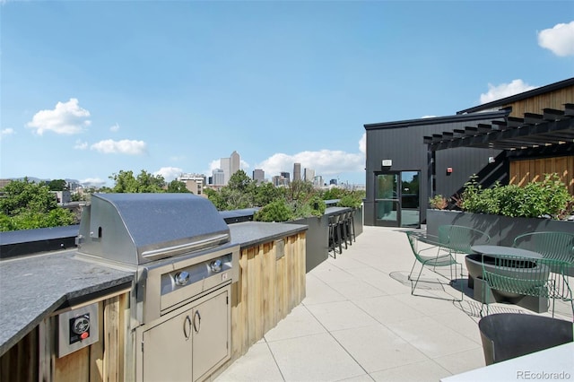 1601 Park Ave # 106, Denver, CO 80218 - view of patio with exterior kitchen, a city view, and a pergola