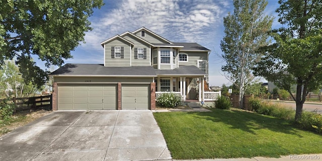 view of front of home featuring covered porch, a front yard, and a garage