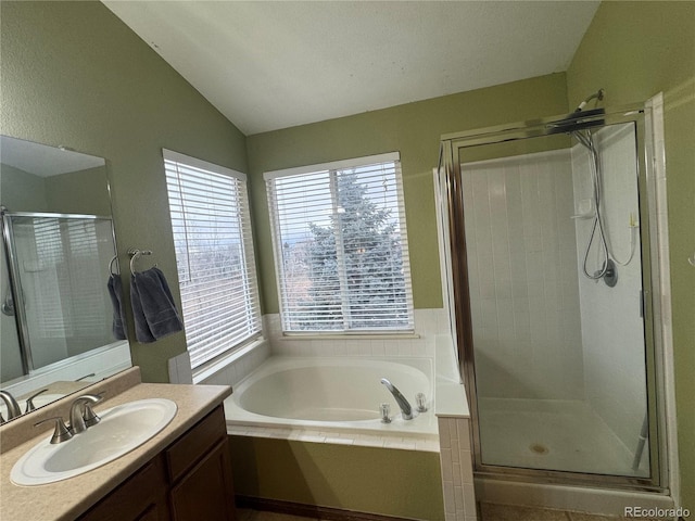 bathroom with vanity, lofted ceiling, and independent shower and bath