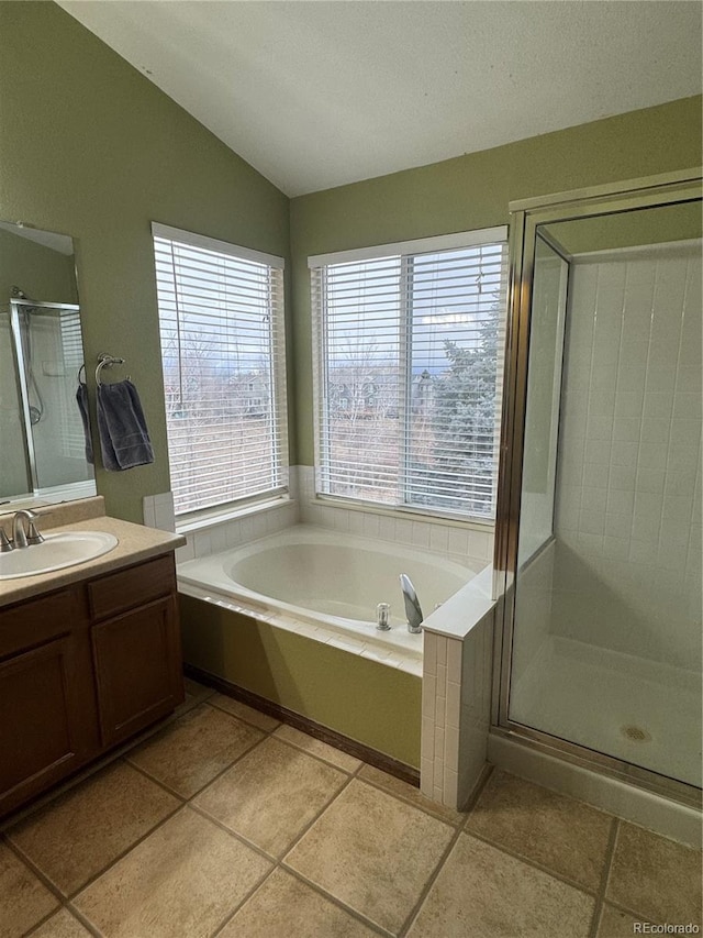 bathroom with vaulted ceiling, tile patterned floors, separate shower and tub, and vanity