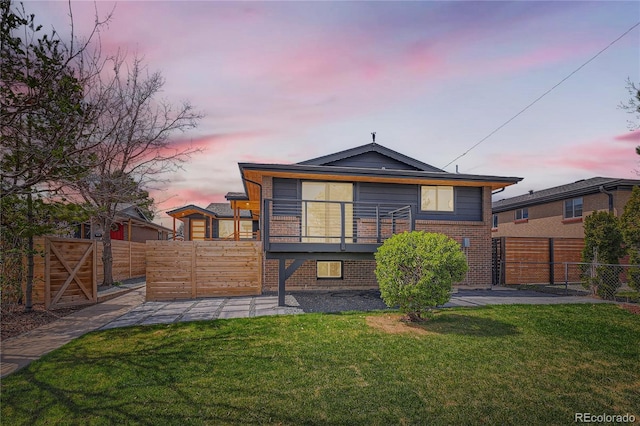 2065 Depew St, Edgewater, CO 80214 - back of property at dusk featuring brick siding, a gate, and a wooden deck