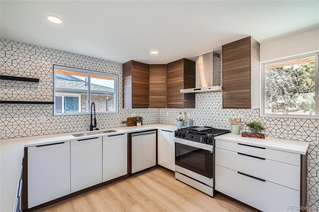 2065 Depew St, Edgewater, CO 80214 - kitchen with black gas range, a sink, stainless steel dishwasher, wall chimney exhaust hood, and modern cabinets