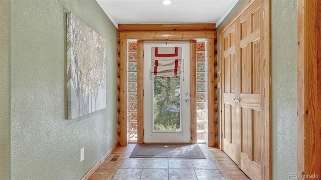 entryway featuring light tile patterned floors and a textured wall